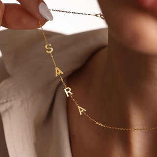 Detalle del collar con iniciales personalizadas en acabado plateado