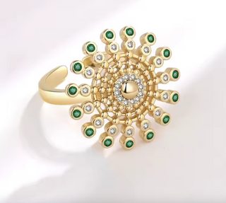 Detalle anillo antiestrés diseño sol con circonitas verdes
