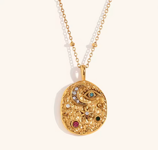 Colgante dorado con incrustaciones brillantes, estilo boho glam, sobre cuello femenino.